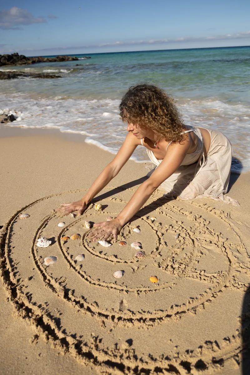 Laura creando espiral con conchas en la playa